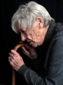 Oudere vrouw leunend op een wandelstok