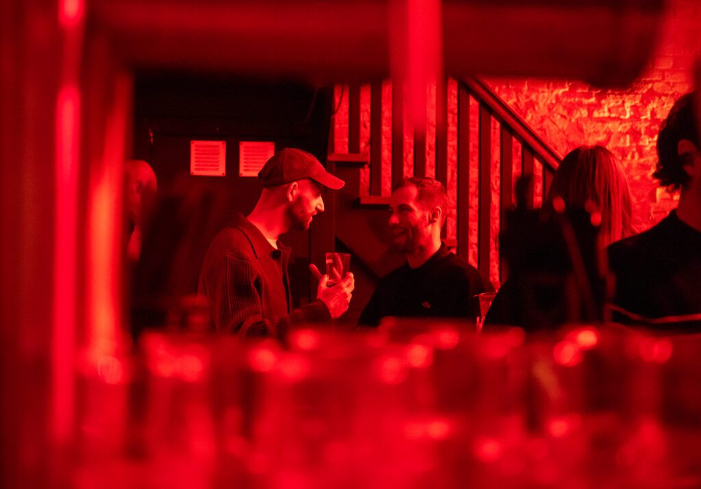 Sfeervolle close-up van proostmoment tijdens zakelijk event – storytelling in beeld door Amstellie Studio.