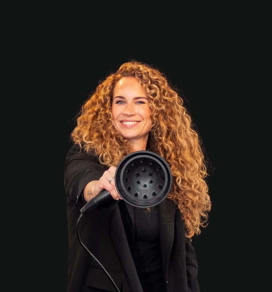 Professioneel portret van een mannelijke stylist met rustige blik, vastgelegd in een lichte, moderne omgeving.